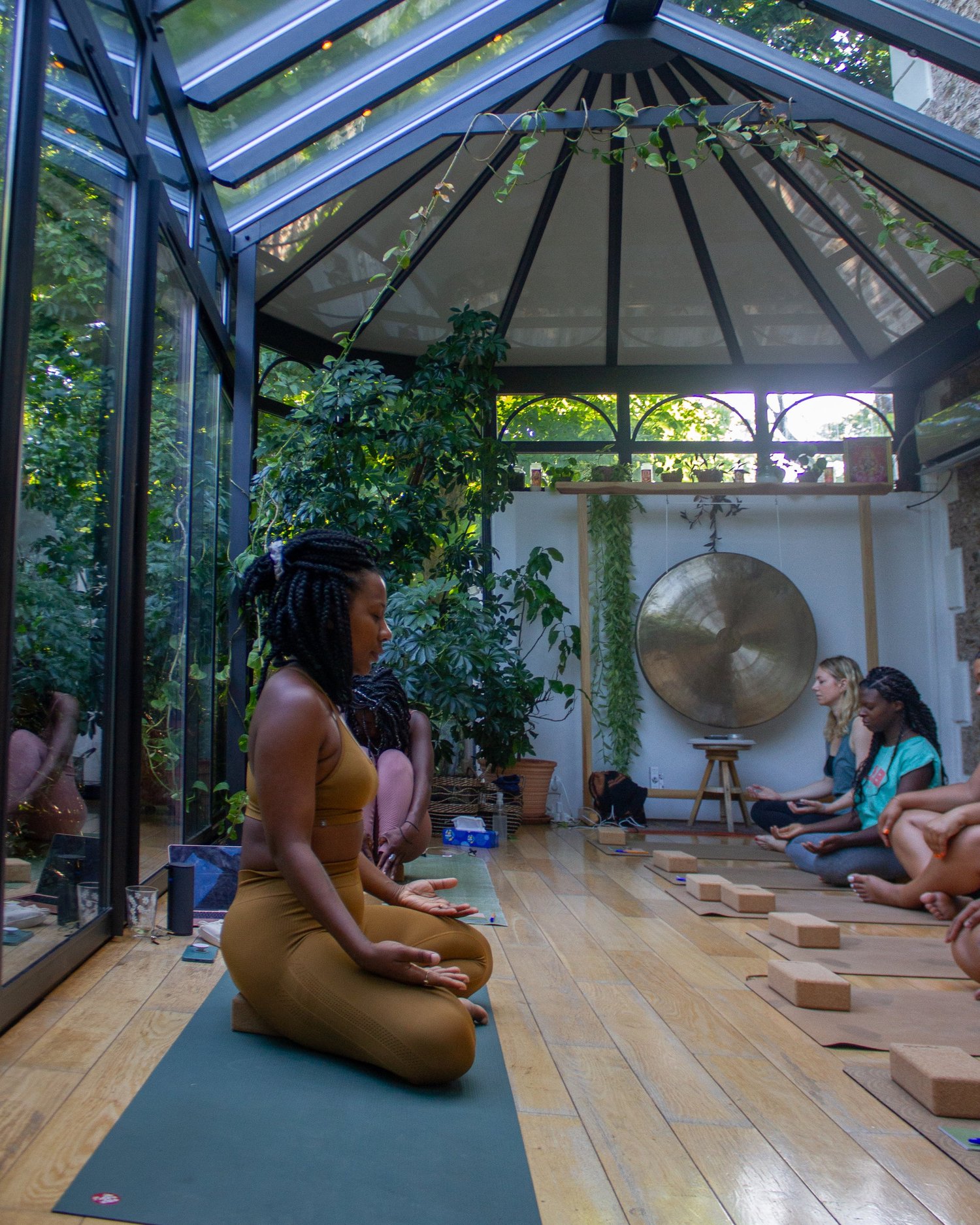 Cynthia Kå assise sous la verrière, avec le groupe et le gong